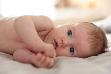 Sevimli yeni doğmuş bebek yatakta uzanıyor, yakın plan.