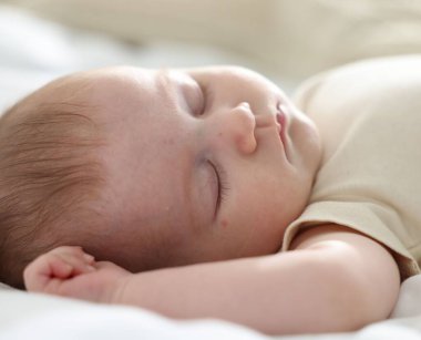 Yeni doğmuş şirin bebek evde yatakta uyuyor.