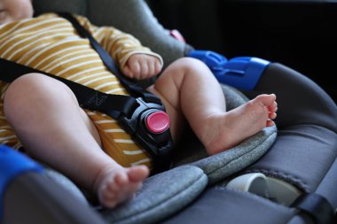 Sevimli küçük bebek araba koltuğuna bağlanmış, yakın plan.