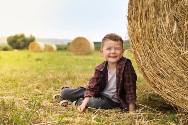 Yazın saman balyasının yanındaki küçük çocuk. Metin için boşluk