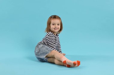 Açık mavi arka planda şirin bir kız.