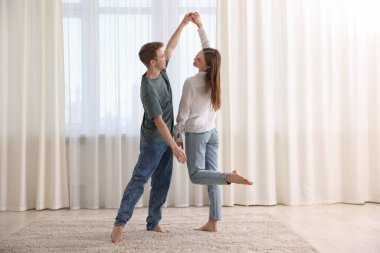 Mutlu genç çift evde dans ediyor.