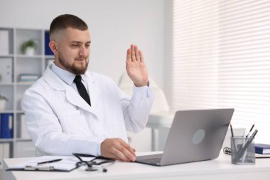 Klinikte bilgisayarla online danışmanlık yapan bir doktor