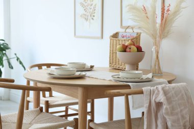 Yemek odasında güzel bir masa, sandalye ve dekor var. İç tasarım