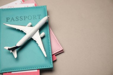Uçak modeli, pasaportlar ve bej arka planda uçuş biletleri, manzaranın üstünde. Metin için boşluk