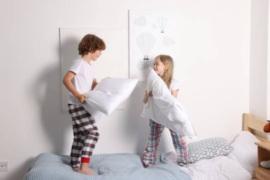 Mutlu çocuklar evde yatakta eğleniyor.