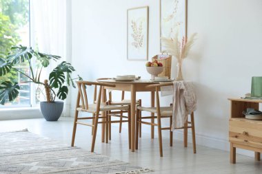 Yemek odasında güzel bir masa, sandalye ve dekor var. İç tasarım