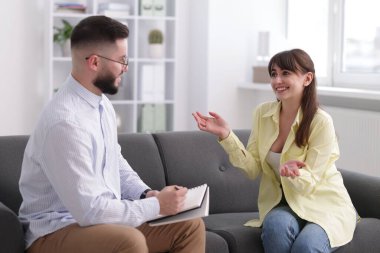 Ofisteki koltukta hastayla çalışan profesyonel psikolog.