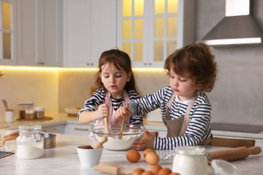 Yemek tarifi. Sevimli çocuklar mutfaktaki masada kurabiye için para kazanıyor.