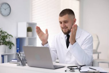 Klinikte bilgisayarla online danışmanlık yapan bir doktor