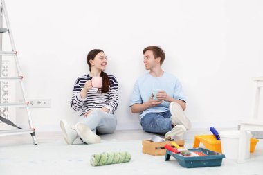 Evde tadilat sırasında kahve içen çift.