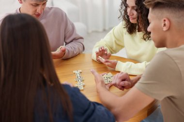 Ahşap masada domino oynayan arkadaşlar.