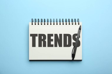 Açık mavi arkaplandaki defter ve kalemdeki yazıtlar, üst görünüm