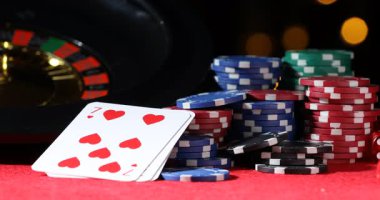 Kumarhane fişleri kırmızı masaya düşüyor bulanık ışıklara karşı, yakın plan