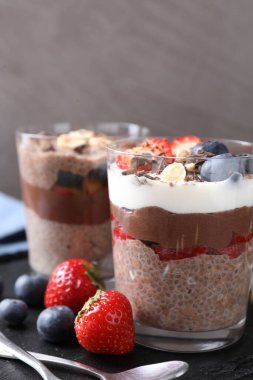 Chia tohumlu, fındıklı ve meyveli lezzetli çikolatalı pudingler masada, yakın plan.