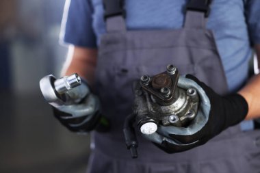 Otomobil parçası. Profesyonel tamirci, hidrolik pompa ve anahtar yuvası kapalı, yakın plan.