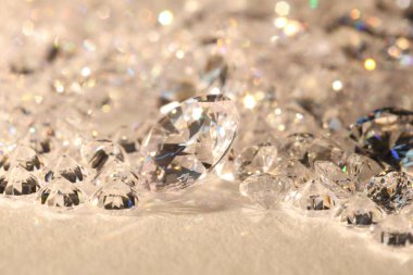 Işıklı arka planda pek çok parlak elmas, yakın plan