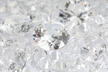 Işıklı arka planda pek çok parlak elmas, yakın plan