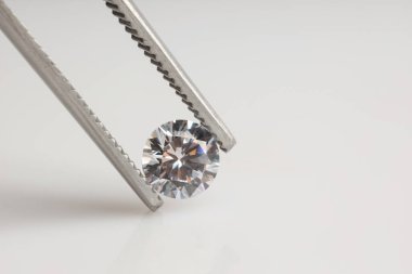 Aydınlık arkaplanlı parlak elmaslı cımbızlar, yakın plan. Metin için boşluk