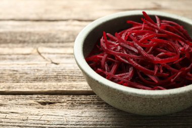 Vejetaryen yemeği. Tahta masadaki klozette çiğ pancar eriştesi, yakın plan. Metin için boşluk