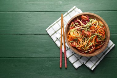 Yeşil ahşap masada servis edilen lezzetli sebzeli şehriyeler, üst manzara. Metin için boşluk