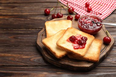 Lezzetli kiraz reçelli tostlar ve ahşap masada taze meyveler, yakın plan. Metin için boşluk