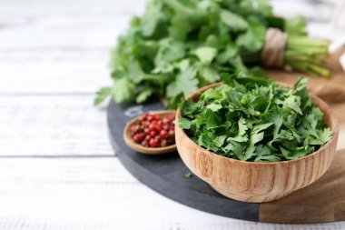 Taze yeşil kişniş ve beyaz ahşap masada biber, yakın plan. Metin için boşluk