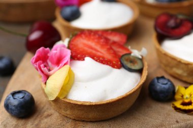 Masada böğürtlenli ve çiçekli tartlar, yakın plan. Tatlı nefis.