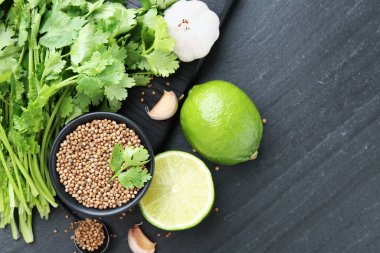 Kasede kişniş çekirdeği, taze kişniş, kireç ve sarımsak koyu dokulu masa, düz yatak. Metin için boşluk