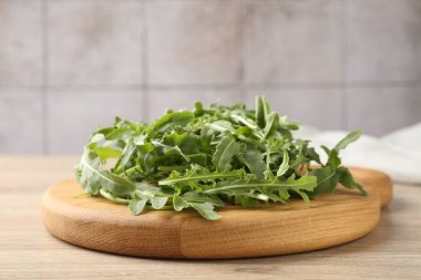 Taze yeşil roka yaprakları açık ahşap masada, yakın plan.