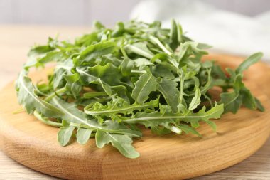 Taze yeşil roka yaprakları açık ahşap masada, yakın plan.