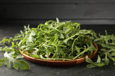 Taze yeşil roka yaprakları siyah masada, yakın plan.