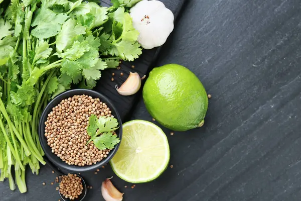 Kasede kişniş çekirdeği, taze kişniş, kireç ve sarımsak koyu dokulu masa, düz yatak. Metin için boşluk