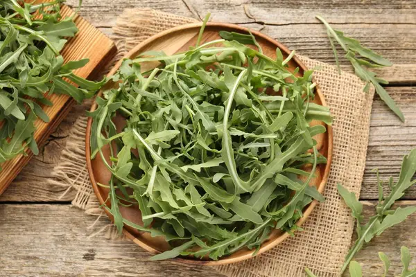 Taze yeşil roka yaprakları ahşap masanın üzerinde, düz yatıyordu.