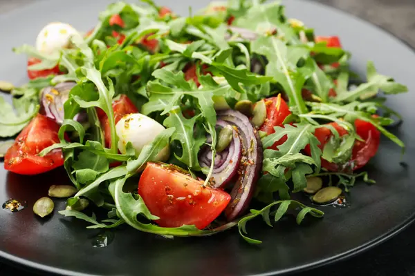 Lezzetli salata roka, mozarella ve sebzeler masada, yakın plan.