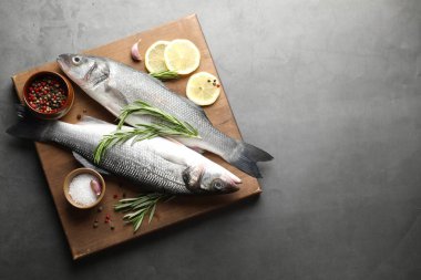 Gri masadaki baharatlı taze çiğ deniz kabuğu balığı, yazı için üst manzara ve boşluk. Deniz ürünleri lezzetleri.