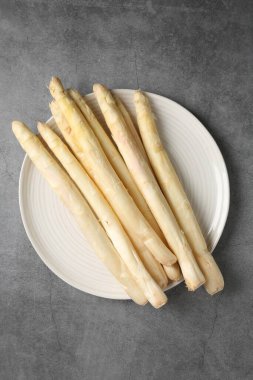 Gri desenli masa üzerinde çiğ beyaz kuşkonmaz mızrakları.