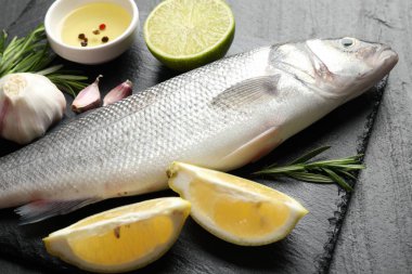 Siyah masada baharatlı taze çiğ deniz kabuğu, yakın plan. Balık ve deniz ürünleri lezzetleri