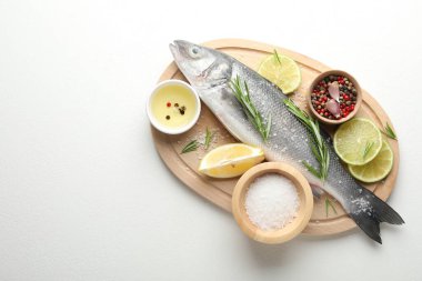 Beyaz masadaki baharatlı taze çiğ deniz kabuğu balığı, üst manzara ve yazı için yer. Deniz ürünleri lezzetleri.