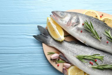 Mavi ahşap masadaki baharatlı taze çiğ deniz kabuğu balığı, üst manzara ve yazı için yer. Deniz ürünleri lezzetleri.