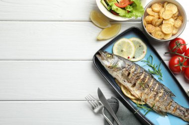 Ev yapımı deniz ürünleri yemeği. Beyaz ahşap masada salata ve patatesle servis edilen lezzetli kavrulmuş deniz kabuğu balığı. Metin için boşluk