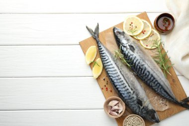 Deniz ürünleri lezzetleri. Taze çiğ uskumrular ve baharatlar beyaz ahşap masada, düz yerde. Metin için boşluk