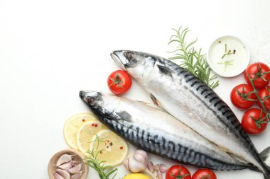 Deniz ürünleri lezzetleri. Taze çiğ uskumrular ve baharatlar beyaz masada, düz yerde. Metin için boşluk