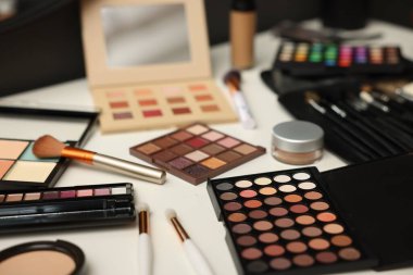 Tuvalet masasında farklı makyaj ürünleri ve fırçalar var.