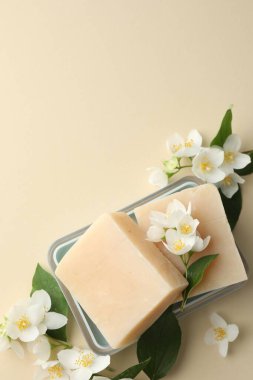 Bej arka planda sabun çubukları ve yasemin çiçekleri. Metin için boşluk