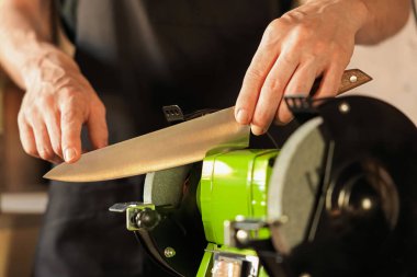 Bıçak keskinleştiren adam içeride, yakın plan.