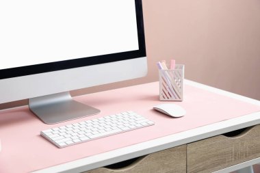 Beyaz masadaki bilgisayarlı ve pembe fareli şık bir iş yeri, yakın plan. Metin için boşluk