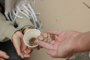 Dışarıdaki evsizlere para veren bir adam.