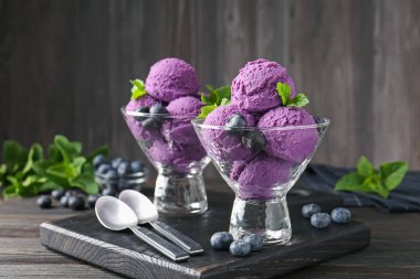 Yaban mersinli şerbet ve tatlı kaselerinde nane, ahşap masada, yakın plan.