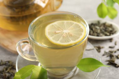 Yeşil çayı limonlu ve yapraklı serinletiyor.
